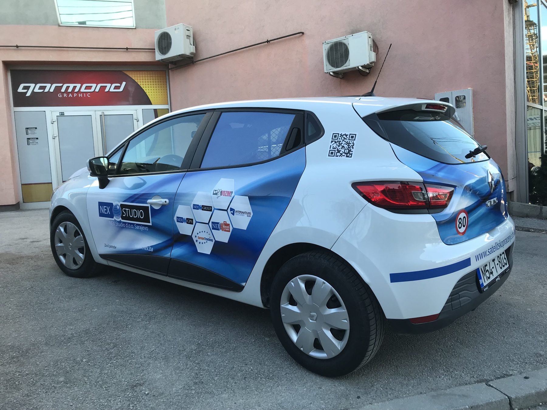 Bijeli automobil s plavom folijom i grafikom